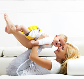 Parent playing with a baby on a clean sofa